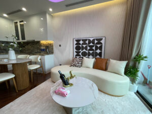 Phòng khách sofa cong và bếp mở trong căn hộ Diamond Crown Hải Phòng